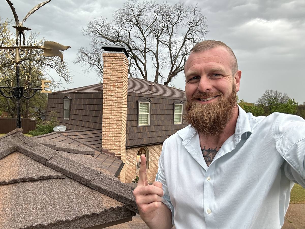 Bobby Persall, owner of Big Bob's Roof Pros, on a finished metal roof in Sherman